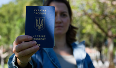 Bà Kateryna Golizdra cầm hộ chiếu Ukraine của mình để chụp ảnh bên ngoài nhà mình ở Margate, Florida, Mỹ ngày 17/11. Ảnh: Reuters.