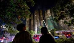 Người dân đứng gần hiện trường vụ hỏa hoạn chết người tại khu nhà ở Wang Fuk Court, trong khi lính cứu hỏa vẫn đang nỗ lực dập tắt đám cháy tại Hong Kong, Trung Quốc vào ngày 27/11. Ảnh: Reuters.