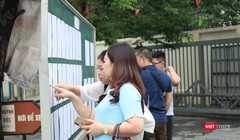 Học sinh và phụ huynh xem lịch thi. Ảnh: Minh Thúy