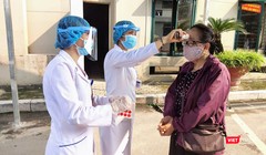 Nhân viên y tế kiểm tra nhiệt độ của người dân (Ảnh - Minh Thuý) 