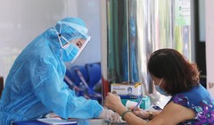 Nhân viên y tế hướng dẫn người dân khai báo y tế (Ảnh: Lê Bảo - Minh Thùy) 
