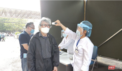 Nhân viên y tế kiểm tra nhiệt độ cho người dân (Ảnh - Minh Thuý) 