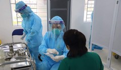 Nữ điều dưỡng Vũ Thị Thanh Thư trò chuyện với cán bộ tiêm chủng trước khi tiêm vaccine phòng COVID-19 (Ảnh: Đặng Thanh) 