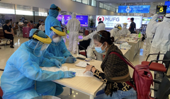 Nhân viên y tế hướng dẫn hành khách khai báo y tế ngay tại sân bay (Ảnh - Hồng Hạnh) 