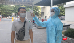 Nhân viên y tế kiểm tra nhiệt độ của người dân (Ảnh - Minh Thuý) 
