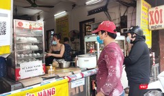 Người dân xếp hàng mua xôi bán mang về (Ảnh - Minh Thuý) 