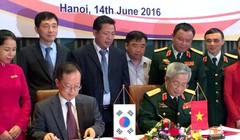 Thượng tướng Nguyễn Chí Vịnh (phải) và ông Chang Jae Yun ký kết biên bản hợp tác khắc phục hậu quả bom mìn sau chiến tranh - Ảnh: Q.TR..