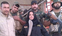 "Bà nội trợ" Wahida Mohamed Al-Jumaily đứng bên các chiến binh dưới quyền. (Nguồn: Independent).