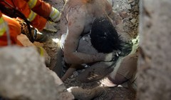 Hình ảnh người cha công nhân dùng thân mình che chắn cho con gái gây xúc động mạnh - Ảnh: AFP.