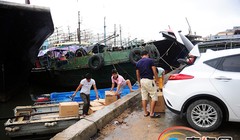 Ngư dân cảng Tam Á, Hải Nam, chất lương thực lên thuyền con, chở ra ngoài tàu lớn. Ảnh: HiNews