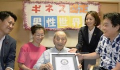 Cụ Yasutaro Koide (giữa) nhận giấy chứng nhận Kỷ lục Thế giới Guinness cụ ông cao tuổi nhất thế giới tại Nagoya ngày 21/8 vừa qua. (Ảnh: Kyodo/TTXVN)