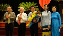 Chủ tịch UBND TP.HCM Nguyễn Thành Phong (giữa) nhận hoa chúc mừng từ ông Lê Hoàng Quân và bà Nguyễn Thị Quyết Tâm - Ảnh: Diệp Đức Minh