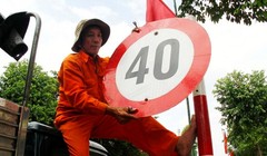 Công nhân Công ty Công trình Đô thị Bình Dương tháo dỡ biển hạn chế tốc độ 40km/h tại đường Thích Quảng Đức, TP Thủ Dầu Một chiều 28/1. 