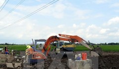 Đơn vị kiểm định chất lượng bê tông tiến hành khoan trụ bê tông cột điện cao thế để lấy mẫu kiểm định chất lượng. (Ảnh: Văn Đạt/TTXVN)