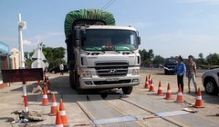 Lực lượng chức năng tiến hành kiểm soát tải trọng xe. (Ảnh: Sỹ Tuyên/TTXVN)