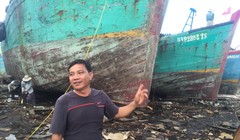 Ông Trà Văn Hoành bên tàu gỗ cỡ lớn đang bảo trì, sửa chữa định kỳ - Ảnh: MINH ĐỨC