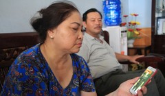 Bà Lê Thị Đào, bác ruột đại úy Lê Văn Đình, đọc tin tìm kiếm cứu nạn máy bay CASA 212 - Ảnh: ĐỨC HIẾU