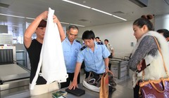 Nhân viên hải quan kiểm tra tư trang hành lý của hành khách tại sân bay quốc tế Đà Nẵng - Ảnh: Sa Sa