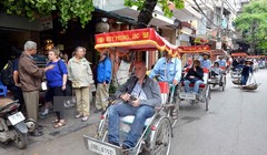 Du khách nước ngoài thăm phố cổ Hà Nội bằng xe xích lô. (Ảnh: Thanh Hà/TTXVN)