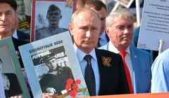 Tổng thống Nga V.Putin mang ảnh người Nga diễu hành cùng với Trung đoàn bất tử nhằm bảo vệ ký ức lịch sử về Ngày Chiến Thắng trong Chiến tranh giữ nước (Ảnh Sputnik)