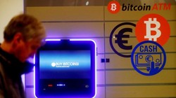 Một người đàn ông đi ngang qua một cây ATM bitcoin ở Vilnius, Litva. Ảnh: CNBC