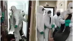 Nhân viên công tác cưỡng chế bệnh nhân rời nhà đi cách ly (Ảnh: Đông Phương)