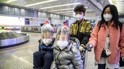 Hành khách ở Quảng Châu tự tạo mặt nạ phòng hộ bằng vỏ thùng đựng dầu ăn (Ảnh: EPA)