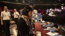 Kiểm tra thân nhiệt hành khách trước khi lên bờ ở Sihanoukville (Ảnh: The New York Times).