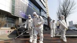 Các nhân viên phòng dịch phun thuốc khử trùng khu vực nhà thờ của giáo phái Shincheonji ở Daegu (Ảnh: Yonhap)
