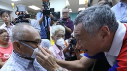 Do dịch bệnh bùng phát trở lại, Singapore ban hành lệnh bắt buộc người ra đường phải đeo khẩu trang. Trong ảnh: Thủ tướng Lý Hiển Long đeo khẩu trang cho người dân (Ảnh: Guancha).