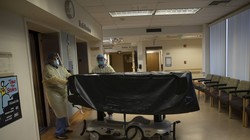 Dịch bệnh COVID-19 lây lan mạnh ở Mỹ đã khiến hơn 12.45 triệu người nhiễm bệnh và hơn 262 ngàn người chết. Trong ảnh: nhân viên một bệnh viện ở California vận chuyển thi thể bệnh nhân COVID-19 bị chết (Ảnh: AP).