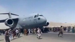 Cảnh người dân bám và chạy theo khi chiếc C-17 cất cánh (Ảnh: Đông Phương).