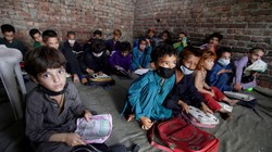 Trẻ em Afghanistan theo bố mẹ chạy sang Pakistan tị nạn (Ảnh Reuters).