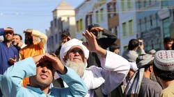  Dân chúng xem thi thể bị Taliban treo lên thị chúng ở thành phố Herat (Ảnh AP).