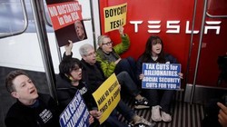 Người biểu tình chống Elon Musk vào ngồi lỳ trong cửa hàng Tesla cản trở hoạt động kinh doanh. Ảnh: QQnews.