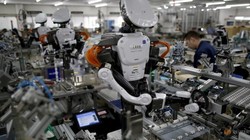 Robot cùng làm việc với nhân viên trong dân chuyền lắp ráp tại một nhà máy của công ty Glory ở phía bắc Tokyo - Ảnh: Reuters