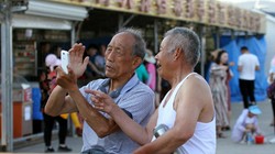 Hai người cao niên đang sử dụng điện thoại di động ở tỉnh Sơn Đông, tháng 5/2017. Ảnh: VCG.