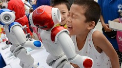 Những em bé đang nô đùa với robot trong một triển lãm ở Trung Quốc - Ảnh: Business Insider.