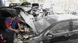 Ông Ng Chee Lun - thợ sửa xe - đang xem xét phần máy của một chiếc xe bị ngâm nước