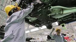 Công nhân làm việc trong phân xưởng lắp ráp ô tô.