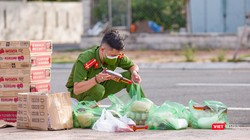 Chiến sĩ trẻ soát lại đơn hàng nhu yếu phẩm của người dân trước khi giao (Ảnh: Nghĩa Hiếu)