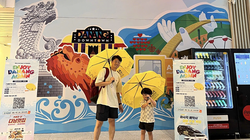 Du khách Hàn Quốc thích thú với chiếc dù có logo, hình ảnh du lịch Đà Nẵng