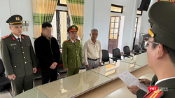 Công an TP Huế tống đạt quyết định khởi tố Hoàng Trung Nghĩa (thứ 2 từ trái sang). Ảnh: Công an cung cấp.