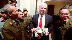 2-	Thượng nghị sỹ John McCain cầm những tấm hình đen trắng chụp ông khi bị bắt làm tù binh ở Hà Nội năm 1967 trong một chuyến đến thăm Bảo tàng quân đội nhân dân Việt Nam ngày 9/10/1992.Ảnh: Hoàng Đình Nam/ AFP.