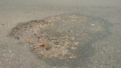 Mặt đường hư hỏng nghi bị tưới hóa chất phá hoại