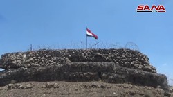 Quân đội Syria thượng cờ trên cao điểm Tal Al-Harrah thuộc vùng nông thôn Daraa. Ảnh video