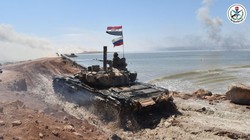 Xe tăng Syria vượt vật cản tấn công. Ảnh Bộ Quốc phòng Syria.