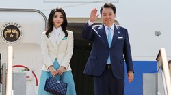 Tổng thống Yoon Suk-yeol (phải) và phu nhân lên máy bay rời Hàn Quốc. Ảnh: AFP