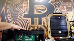 Thiết bị khai thác bitcoin trước logo đồng mã hóa, ảnh chụp ở Đài Loan hồi tháng 6. ẢNH: REUTERS
