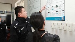 Một cảnh sát tại Bắc Kinh đang giải thích cho người nhà tù nhân về cách gửi tiền cho họ qua ứng dụng thanh toán Alipay.